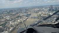 Blick aus einem Hubschrauber auf die London. In der Mitte des Bildes ist der Fluss Themse zu sehen.