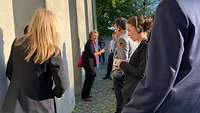 Teilnehmende stehen mit der Museumsführerin vor einem Stehlenfeld