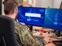 KI Labor in Nienburg Ein Soldat sitzt vor zwei Bildschirmen und arbeitet daran