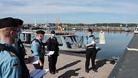 Mehrere Marinesoldaten an einem Bootshafen.