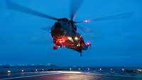 Ein Hubschrauber landet in den frühen Morgenstunden auf dem Deck eines Schiffes.