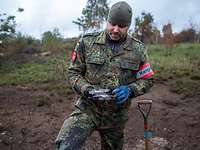 Stabsfeldwebel S. bei der Erfolgskontrolle Ein Soldat steht auf einem Truppenübungsplatz und hält in seinen Händen einen Splitter einer gesprengten Granate.