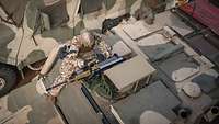 Eine Soldatin montiert eine Waffe auf einem Militärfahrzeug