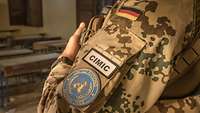 Ein Uniform-Ärmel mit deutschem Hoheitsabzeichen, United Nations Aufnäher und der Kennzeichnung „CIMIC“