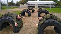 Soldaten liegen mit dem Rücken auf Reifen.