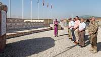 Eine Delegation des Deutschen Bundestages steht auf einer Schotterfläche in Afghanistan