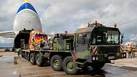 Ein LKW fährt aus einem zivilen Transportflugzeug