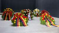 Nahaufnahme von fünf Blumenkränze im Ehrenmal der Bundeswehr