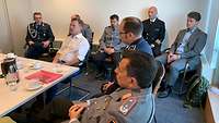 Seminarteilnehmer sitzen im Besprechungsraum der Botschaft