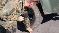 Ein Soldat entfernt Steine aus einem Reifen mit einer Zange