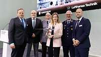 Gruppenbild A350 Übergabe und Taufe in Hamburg Eine Frau, zwei Soldaten und drei Männer präsentieren ein Modell des Flugzeuges
