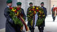 Soldaten vom Wachbataillon tragen Blumenkränze ins Ehrenmal der Bundeswehr