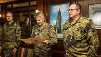 Soldat A in Flecktarn liest anderem Soldaten aus Urkunde vor