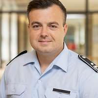 OTL Steven S. blickt in die Kamera. Er steht in einem Flur.