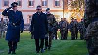 Ein General der Bundeswehr und der hessische Ministerpräsident schreiten die Front ab.