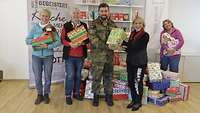 Ein Soldat und mehrere Frauen mit Geschenken