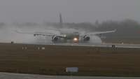 Ein Transportflugzeug landet bei schlechtem Wetter.