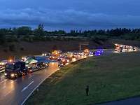 Ein Lkw transportiert ein Kampfflugzeug vom Typ Eurofighter auf der Autobahn bei Dämmerung.