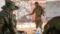 Deutsche und nigrische Soldaten stehen zusammen und besprechen die Ausbildung