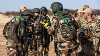 Nigrische Soldaten schlagen einen Pfahl in die Erde beim gemeinsamen Schießbahnaufbau