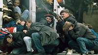 Passanten und ein Soldat in Sarajevo, Bosnien-Herzegowina, unter Beschuss, der Soldat erwidert das Feuer
