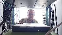 Ein Soldat steht vor einem Serverschrank 