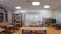 Ein Klassenzimmer mit einem Whiteboard an der Wand sowie einer kleinen Tafel