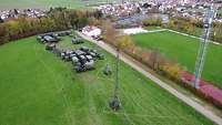 Luftaufnahme eines Gefechtsstandes mit Fahrzeugen, Antennen und Technik.