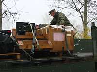 Gut vorbereitet Ein Soldat steht auf der Ladefläche eines Lkw und sichert eine Transportkiste.