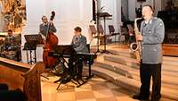 Ein Soldat spielt in einer Kirche das Saxophon.