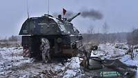 Panzerhaubitze 2000 im verschneiten Gelände, rechts liegt Artillerie-Munition