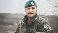 Ein Soldat mit grünem Barett lacht in die Kamera. 