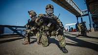Deutsche Soldaten sichern die Evakuierung von Schutzbefohlenen Bewaffnete Soldaten knien im Hafen während der Evakuierungsübung Schneller Adler.
