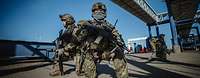 Bewaffnete Soldaten knien im Hafen während der Evakuierungsübung Schneller Adler.