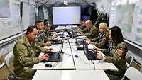 Mehrere türkische Soldaten sitzen an Computern in einem weißen Zelt.