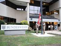 Service members hoist the American flag in front of a building Service members hoist the American flag in front of the building of the Office of Defense Administration, U.S.A. and Canada