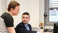 Eine Frau und Mann im Gespräch am Arbeitsplatz