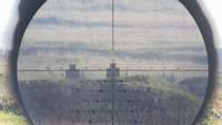 Blick durch das Zielfernrohr Blick durch die Optik des G22. Die Mitte des Zielfernrohres zielt auf eine Schützenscheibe.