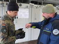 Ein Soldat und ein Mitarbeiter des Kampfmittelbeseitigungsdienstes im Gespräch.