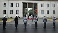 Several soldiers lined up in front of a building