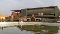 Zwei Soldaten stehen vor einem mit Wasser befülltem Wasserbecken