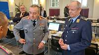 Zwei Soldaten stehen in einem Besprechungsraum und unterhalten sich.