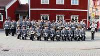 Das Musikkorps vor einem roten schwedischen Haus kurz vor der Show.