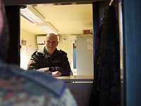 Reservistendienst Leistender im Einsatz Ein Soldat steht als Kunde an einem Tresen und spricht mit dem Feldpostsoldaten