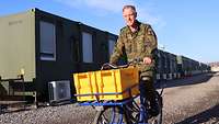 Ein Soldat fährt auf einem Feldpost-Lastenrad mit zwei Briefbehältern für großformatige Sendungen
