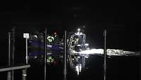 Blaues Motorboot in der Nacht auf einem Fluss.