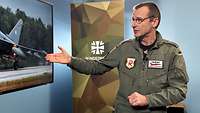 Oberstleutnant Jürgen Schumann zeigt während eines Interviews mit einer Soldatin auf einen Monitor