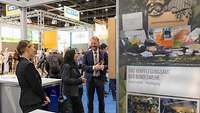 Zwei Frauen und ein Mann am Bundeswehr-Messestand der Grünen Woche in Berlin.