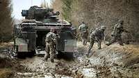 Absitzen vom Schützenpanzer Marder Soldaten steigen aus einem Schützenpanzer Marder aus und laufen ins Gelände.
