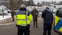 Ein Mann wird der örtlichen Polizeibehörde übergeben.
